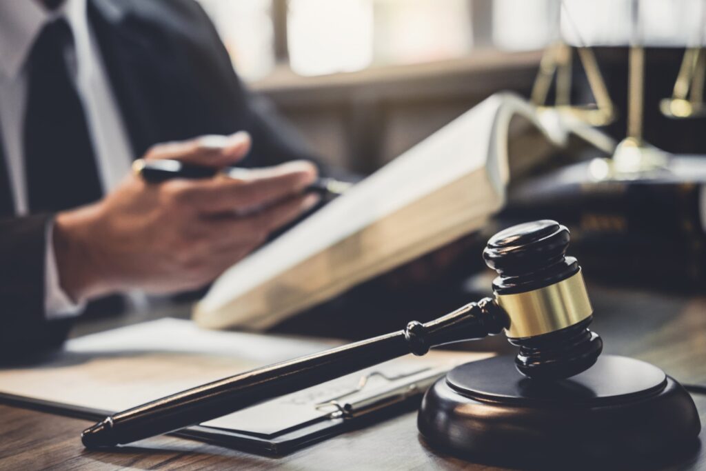 Criminal Defense Lawyer Brandon, FL with a man in a suit reviewing a book and a gavel